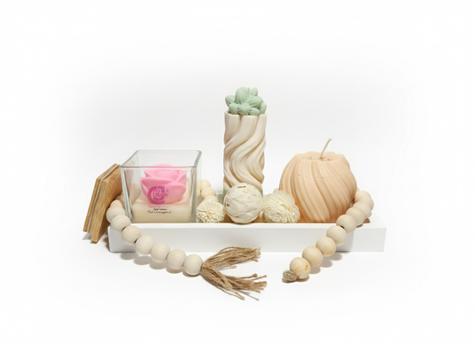 Decorative items including a candle, wooden beads, and a small plant on a white surface.