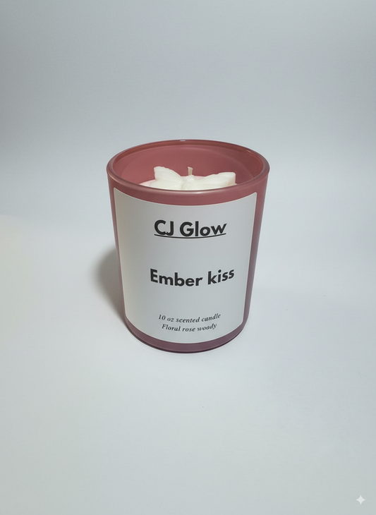 Candle with 'CJ Glow' branding and 'Ember kiss' scent on a white background